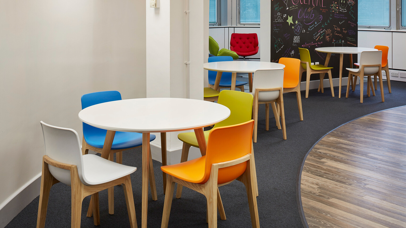 Eleven Elite Bill Chairs With Plastic Seat And Backrest Two In Blue Three In Orange Three In Green Yellow Three In White At Desks In Break Room Environment