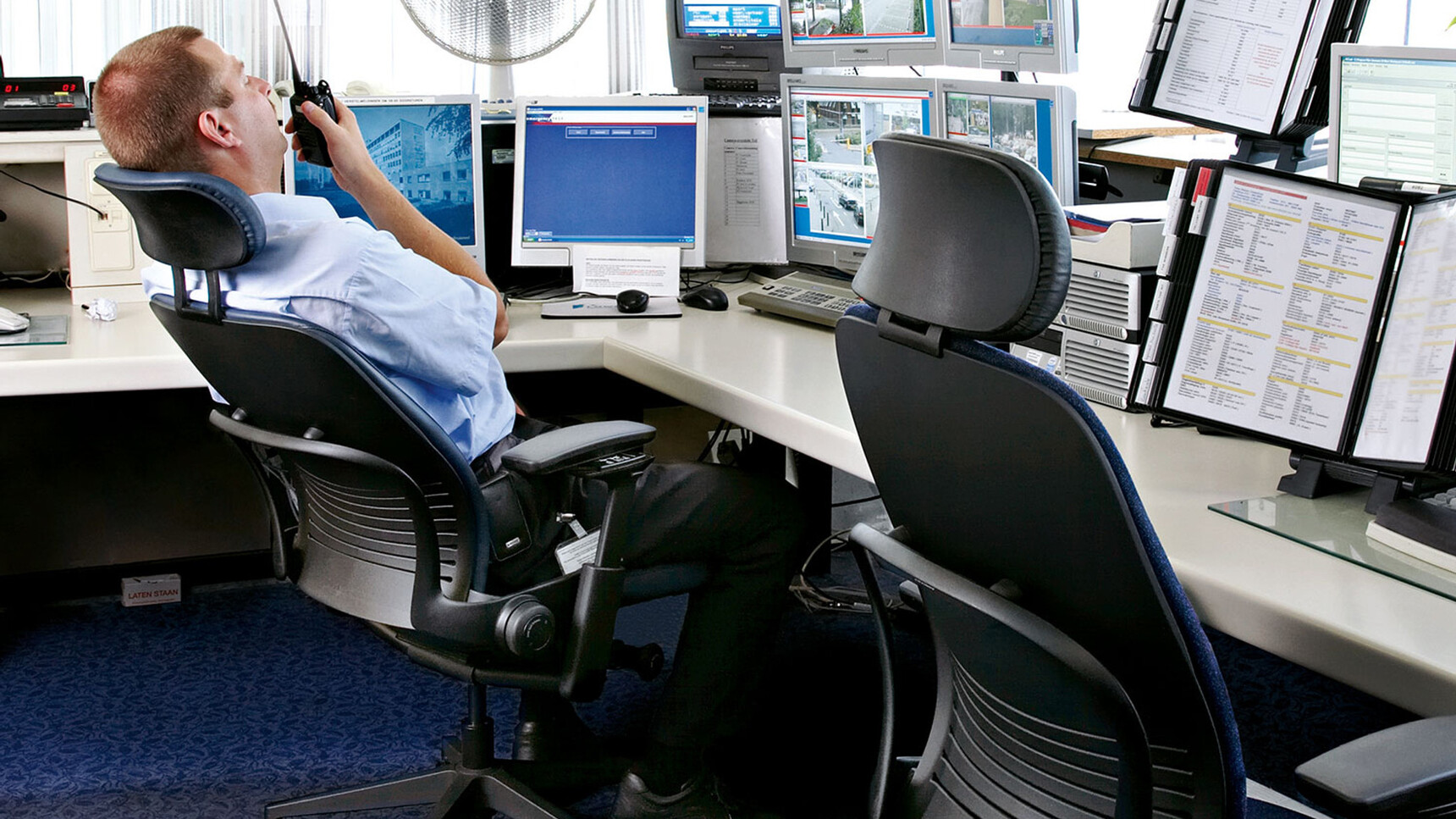 Two Leap V2 Office Chairs With Headrest At Desks One In Use By Screens
