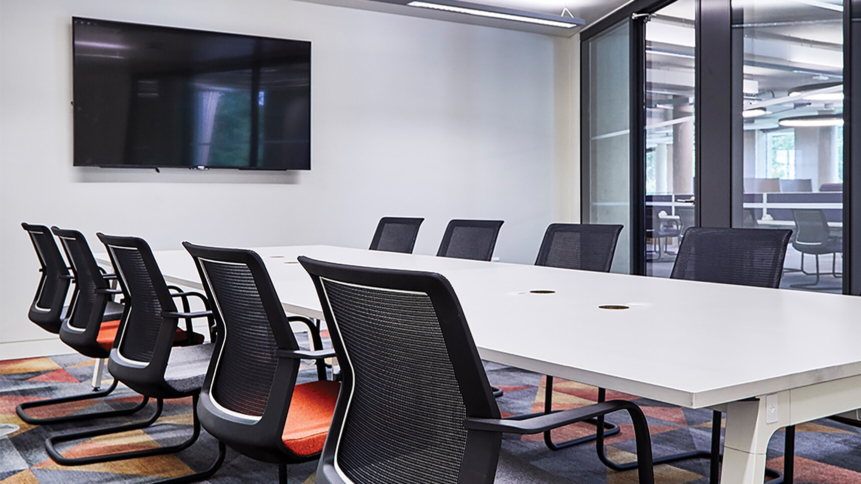 Orangebox Workday Cantilever Armchairs With Orange Seat Upholstery And Black Legs And Backrest At Meeting Table
