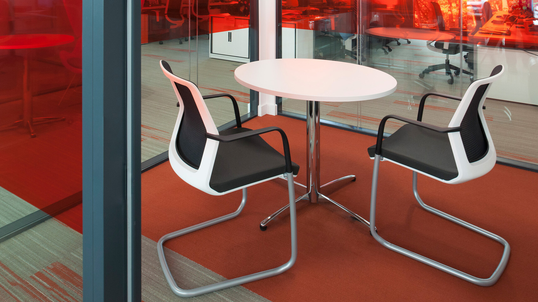 Orangebox Workday Cantilever Armchairs With Black Upholstery And White Back Frame At Table Detail Image