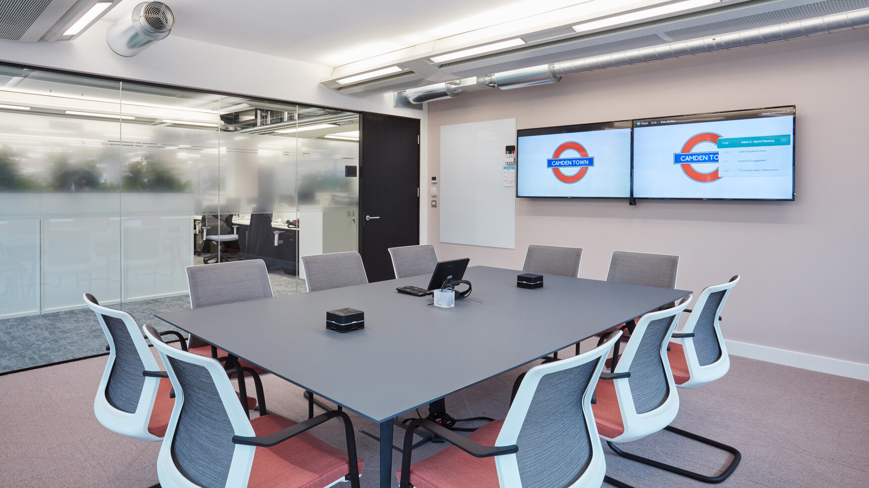 Orangebox Workday Cantilever Armchairs With White Back Frame And Light Red Seat Upholstery At Meeting Table In Meeting Room