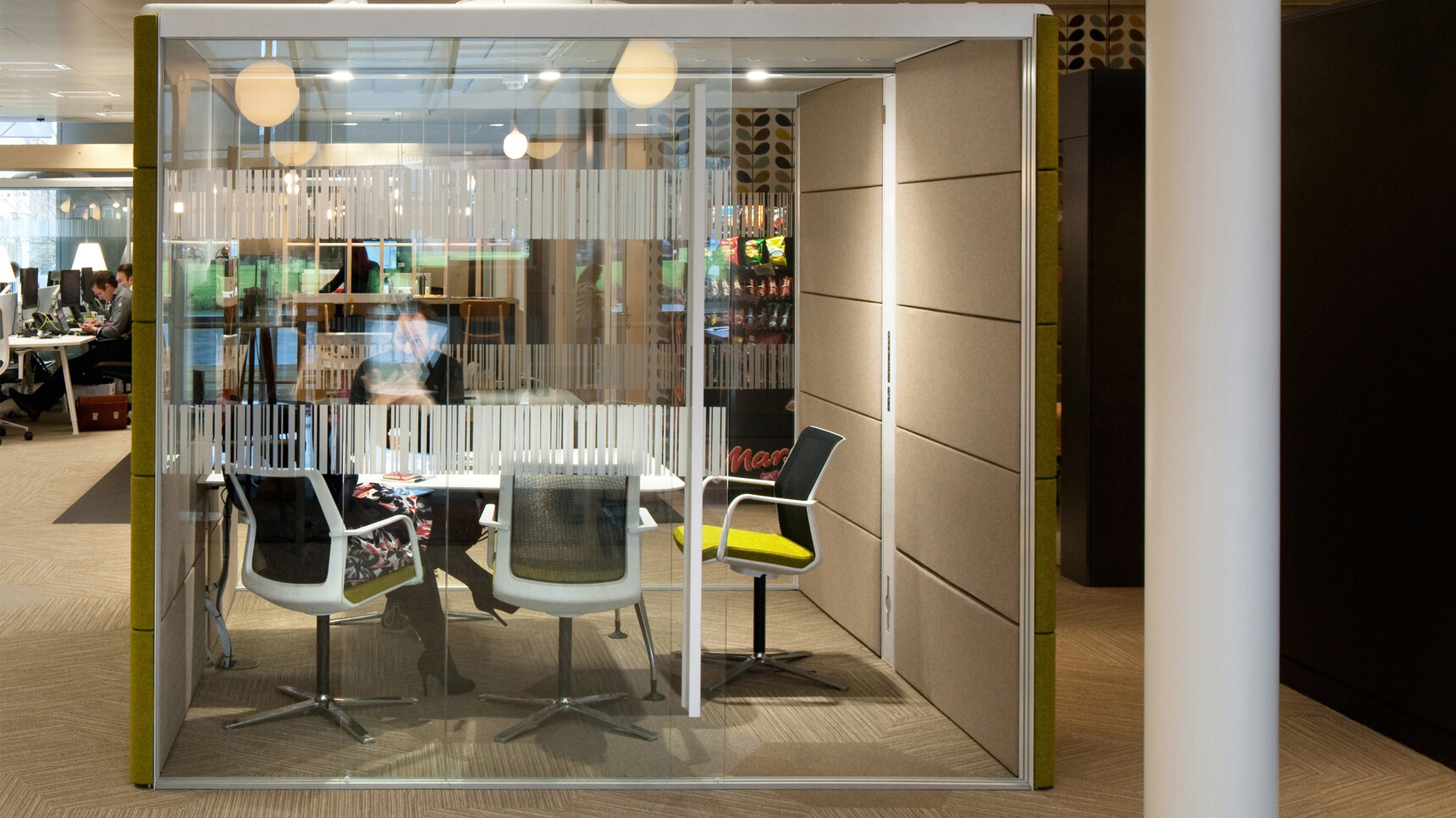 Orangebox Workday Conference Armchair With Black And Light Green Upholstery With White Frame At Table In Meeting Room