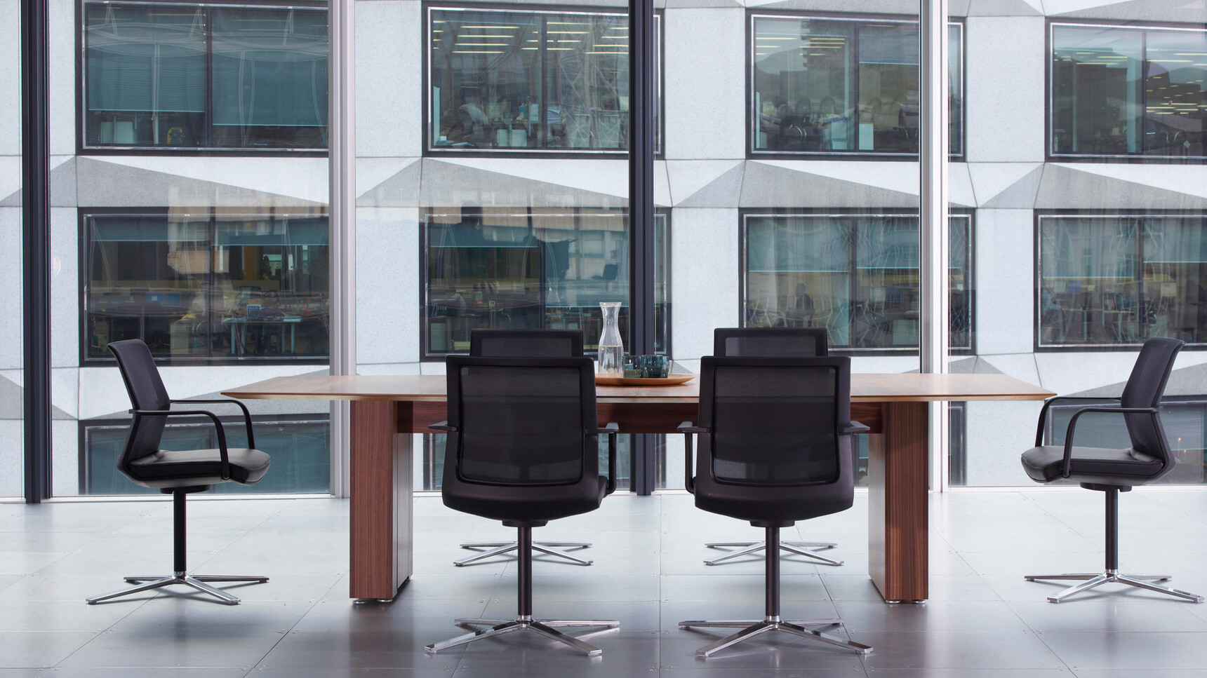 Orangebox Workday Conference Armchair With Black Upholstery At Meeting Table In Office Setting