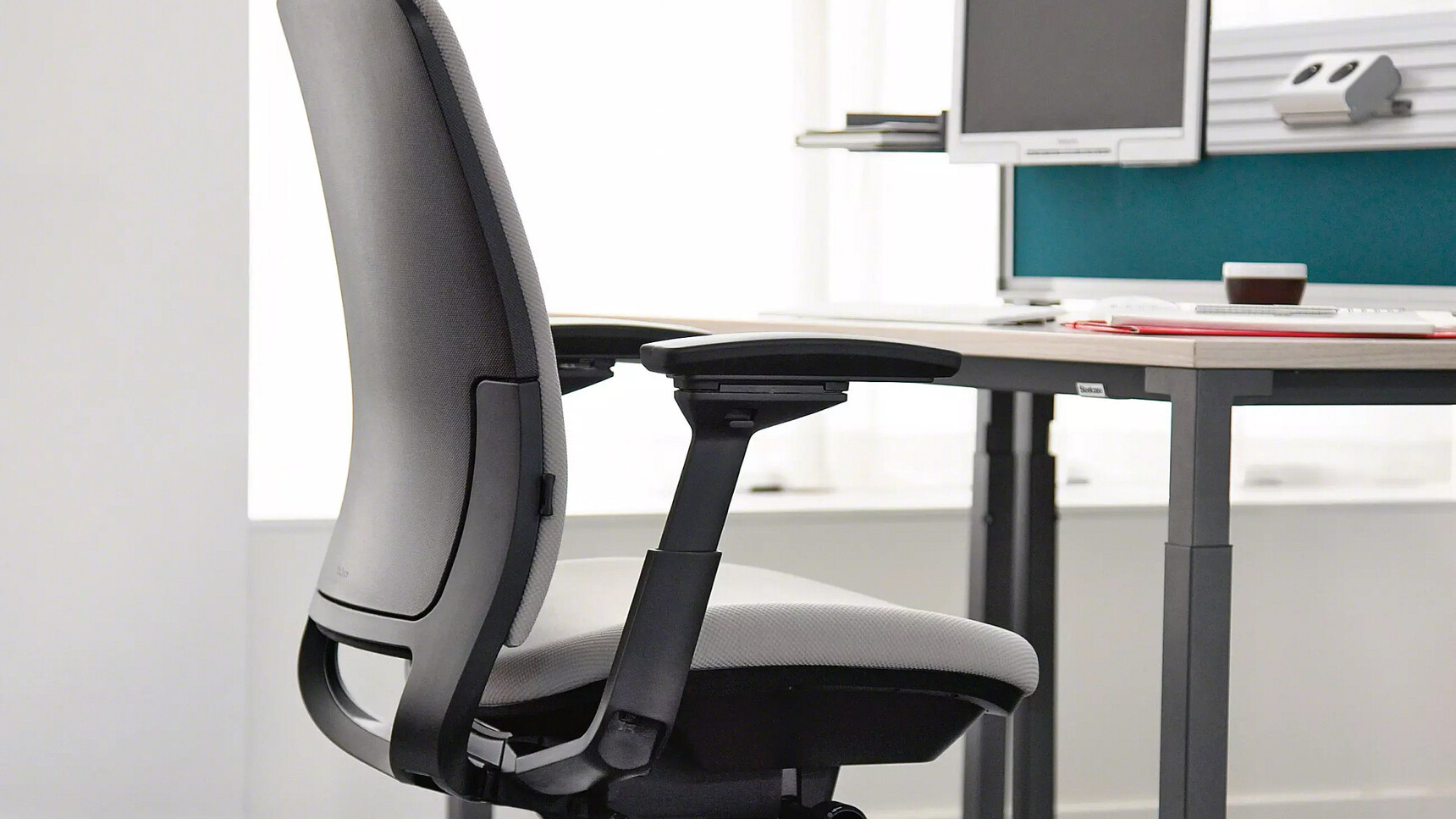 Steelcase Amia Office Task Chair With Light Grey Fabric At Desk Detail Image