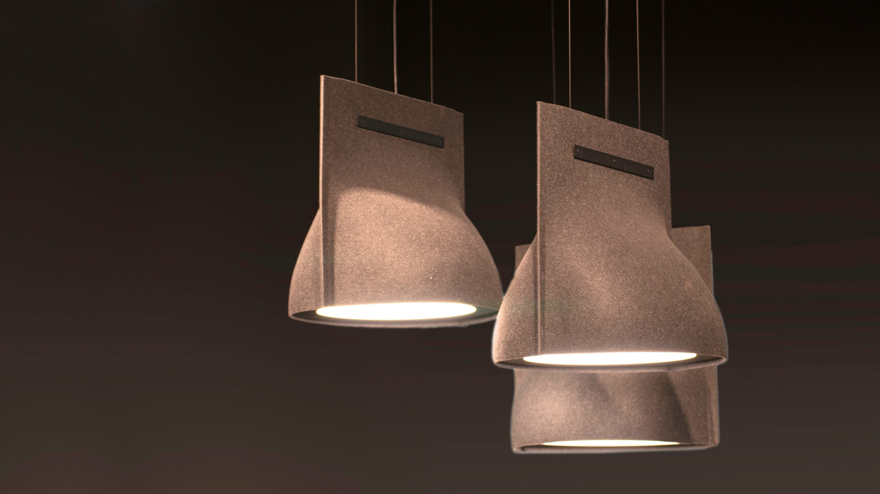 Three BuzziBell LED Light In Brown Upholstery On Dark Background Family Image
