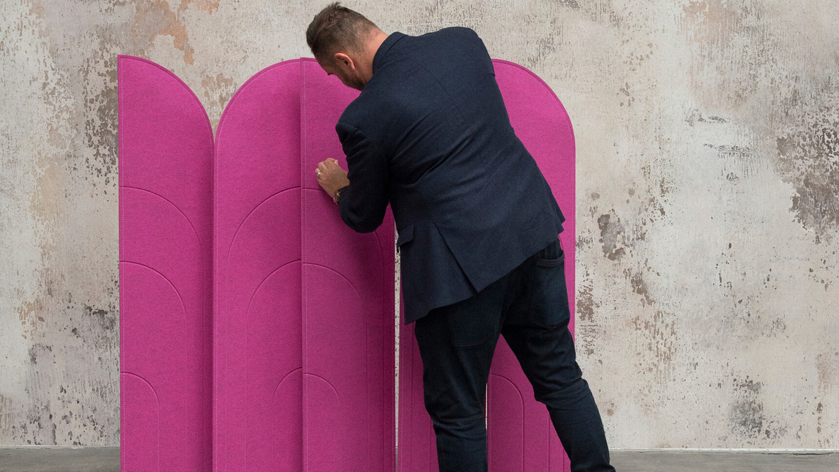 Buzzi Space BuzziBlinds Beach Acoustic Partition With Purple Upholstery Against Grey Wall With The Partitions Facing Each Other And A Person Adjusting Them