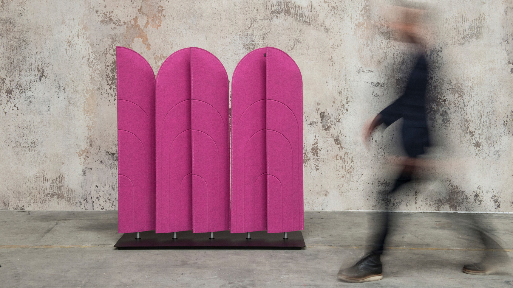 Buzzi Space BuzziBlinds Beach Acoustic Partition With Purple Upholstery Against Grey Wall With Person Walking Past In Motion