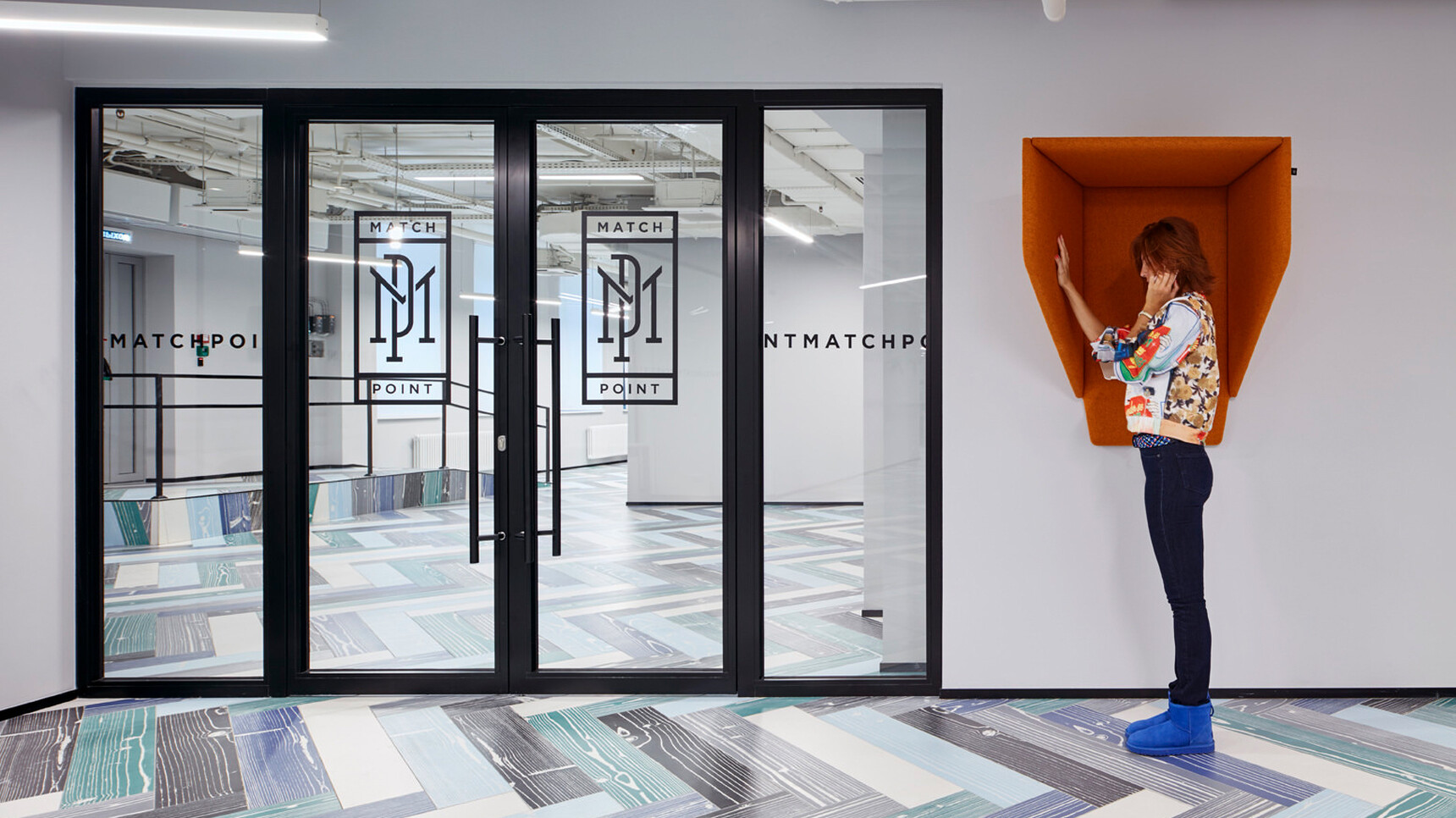 Buzzi Space BuzziHood Acoustic Element In Orange Upholstery With Person Using The Hood Family Image