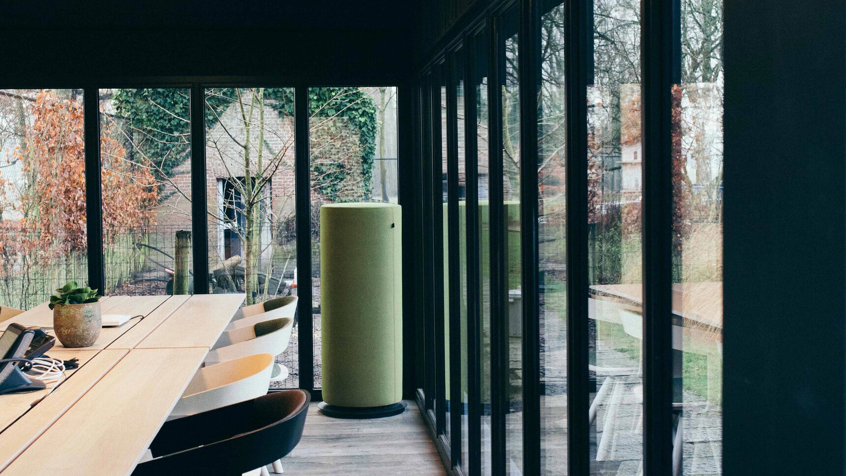 Buzzi Space BuzziTotem Acoustic Cylinder With Green Upholstery In Office Setting