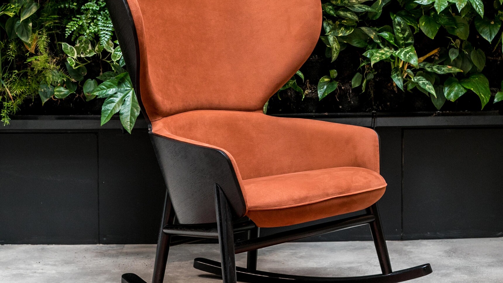 Connection Hygge High Rocker Lounge Chair With Orange Upholstery And Black Frame And Base Detail Image With Plants
