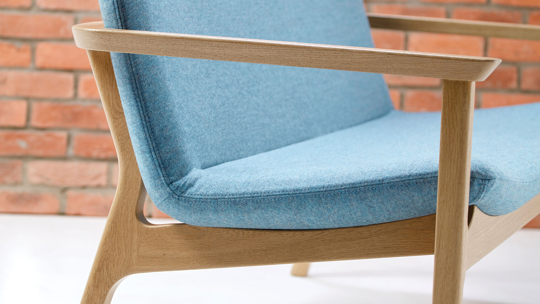 Connection Swoosh Two Seater Sofa With Arms In Blue Upholstery And Oak Frame And Base Detail Image Of Arms