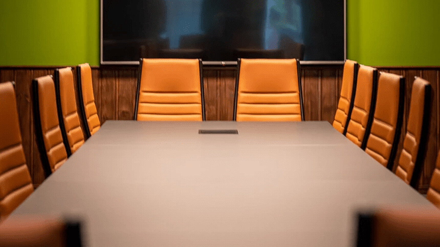 Sitland Classic Low Back Office Chair On Castors With Orange Upholstery At Meeting Table Detail Image