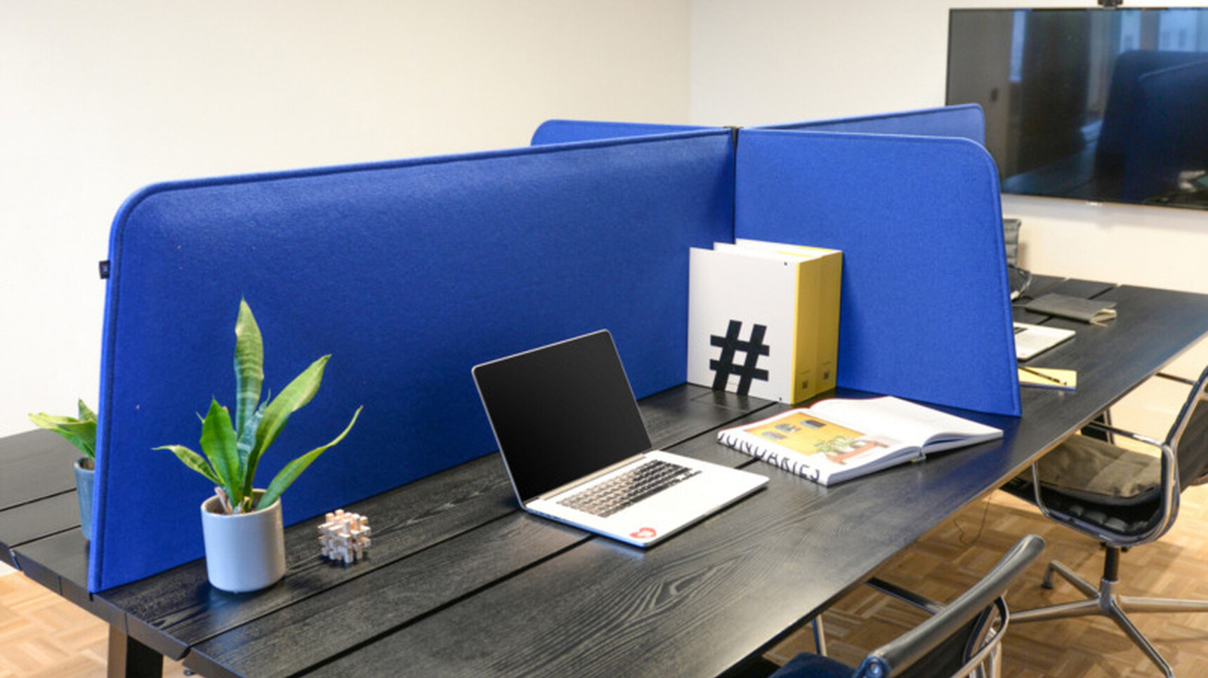 Buzzi Space BuzziDesk Cross Acoustic Desk Divider In Blue Upholstery Detail Image With Plants And Laptop