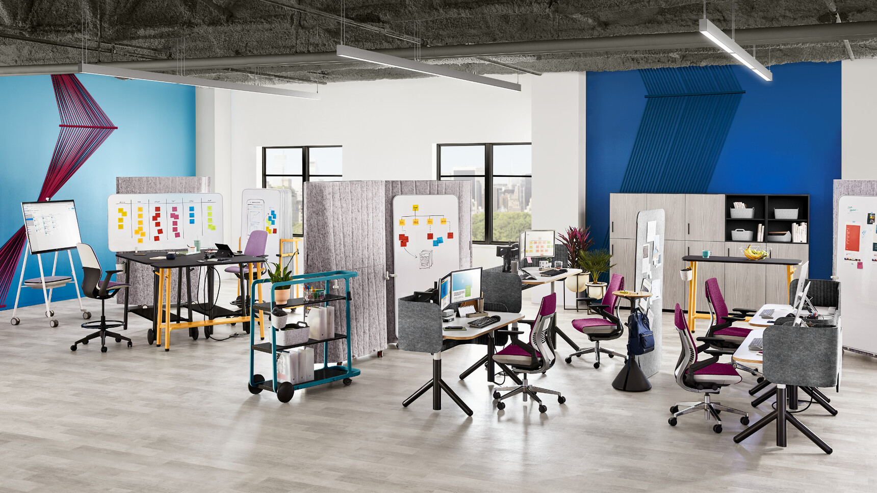 Two Steelcase Flex Height Adjustable Desks With White Table Top Finish And Black Leg Finish And Wood Edges With Privacy Screen In Dark Grey Upholstery With Four Gesture Wrapped Back Office Chairs In Purple Upholstery