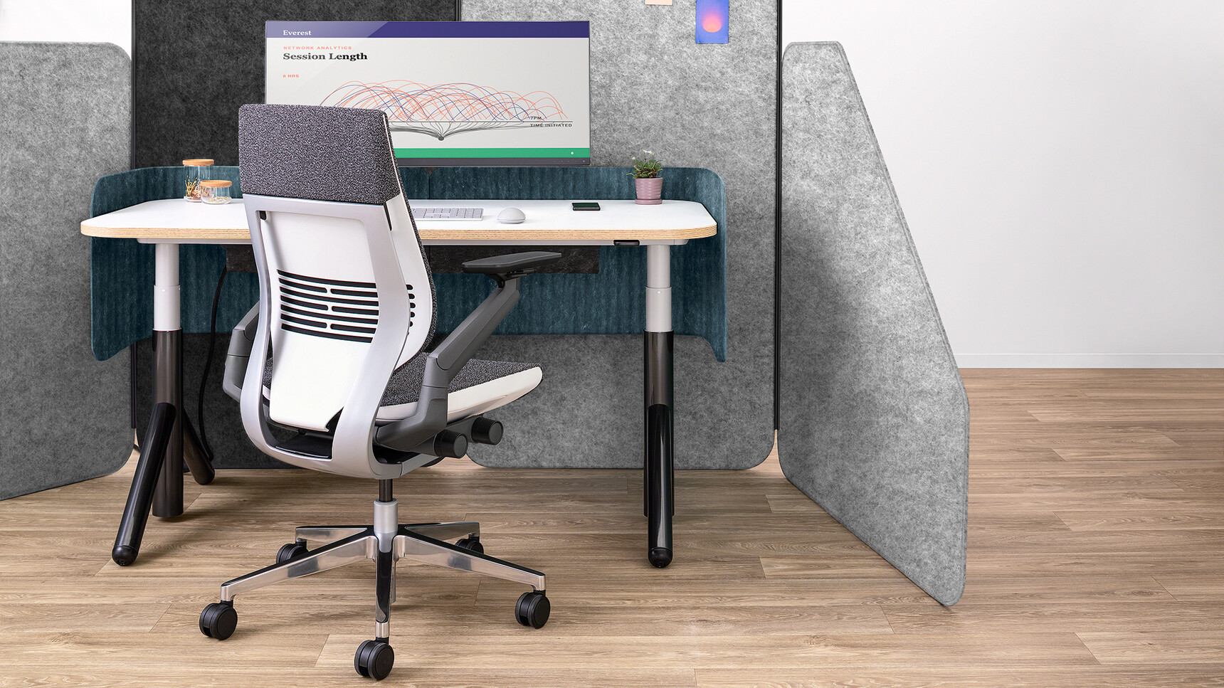 Steelcase Flex Height Adjustable Desk With White Table Top Finish And Black Leg Finish And Personal Screens In Blue Upholstery And Wood Edge With Gesture Wrapped Back Office Chair With Grey Upholstery At Desk