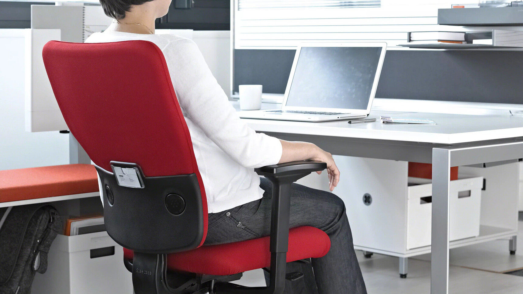 Steelcase Let's B High Back Office Chair Red Upholstery At Bench Desk With Woman on Chair In Office Environment