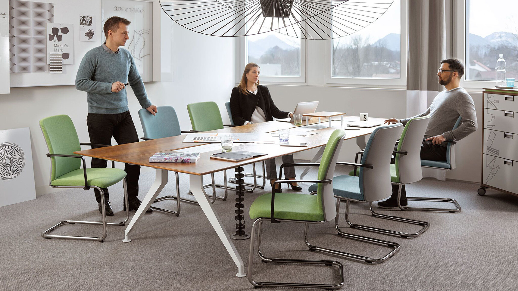 Steelcase 4.8 Barrel Conference Table With Wood Finish And Grey Legs With Eight Steelcase Office Chairs Four In Blue And Four In Green