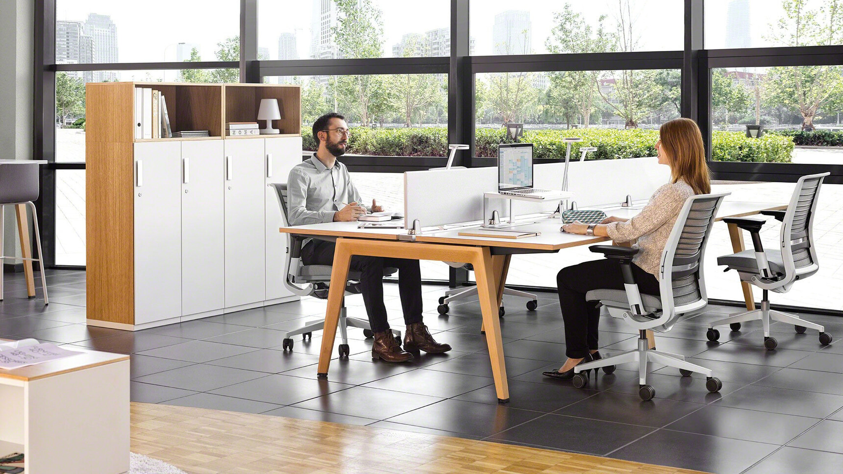Steelcase Two B-Free Back to Back Desks With  White Table Top Finish With Wood Edges And Wood Leg Finish With Four Think Upholstered Office Chairs With Grey Upholstery And Light Grey Frame