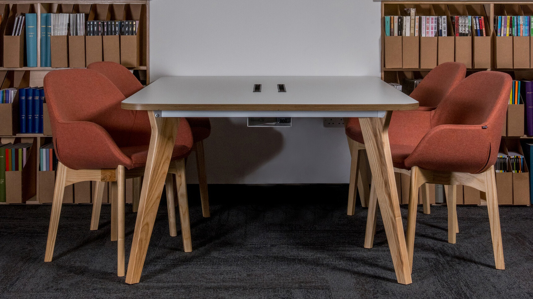 Four Elite Office Furniture Norden Meeting Chairs With Four Leg Base Wood Bases At Table In Office Setting
