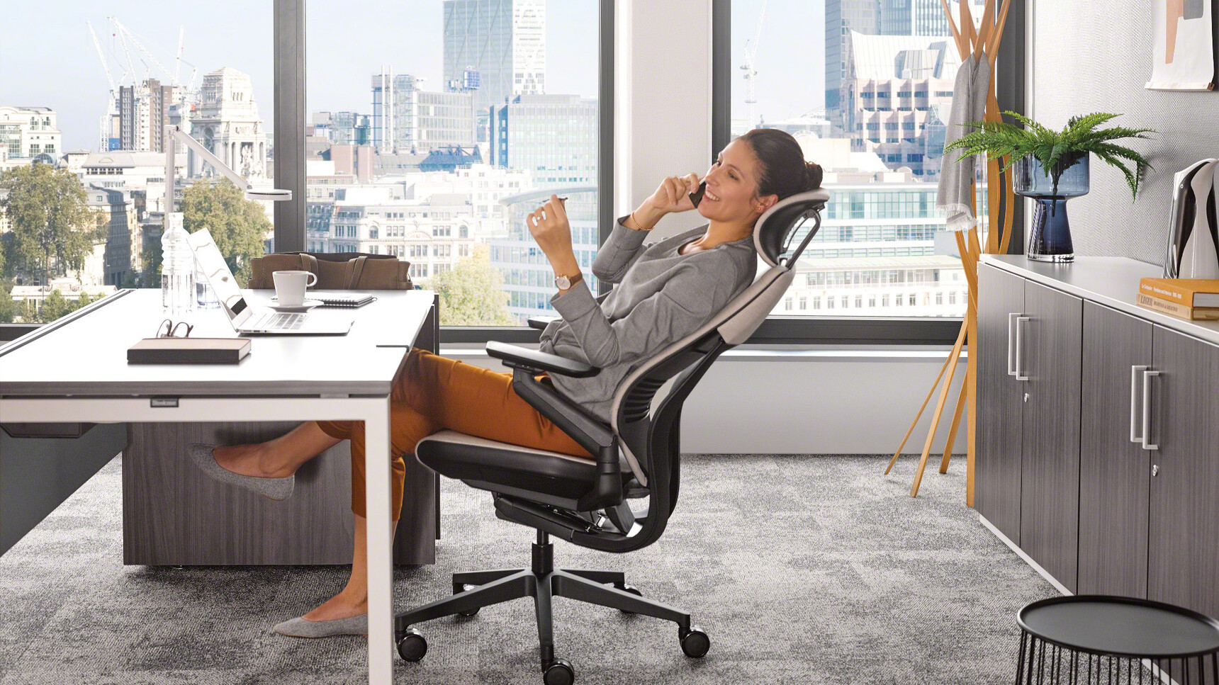 Steelcase Gesture Wrapped Back Office Chair with Headrest White Upholstery With Black Frame And Legs On Castors In Use At Desk