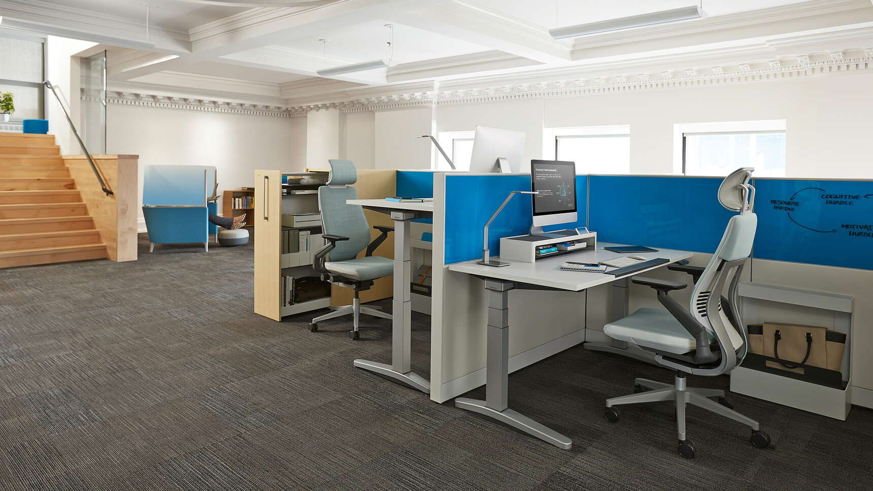 Two Steelcase Gesture Wrapped Back Office Chairs with Headrest And Light Blue Upholstery At Height Adjustable Desks