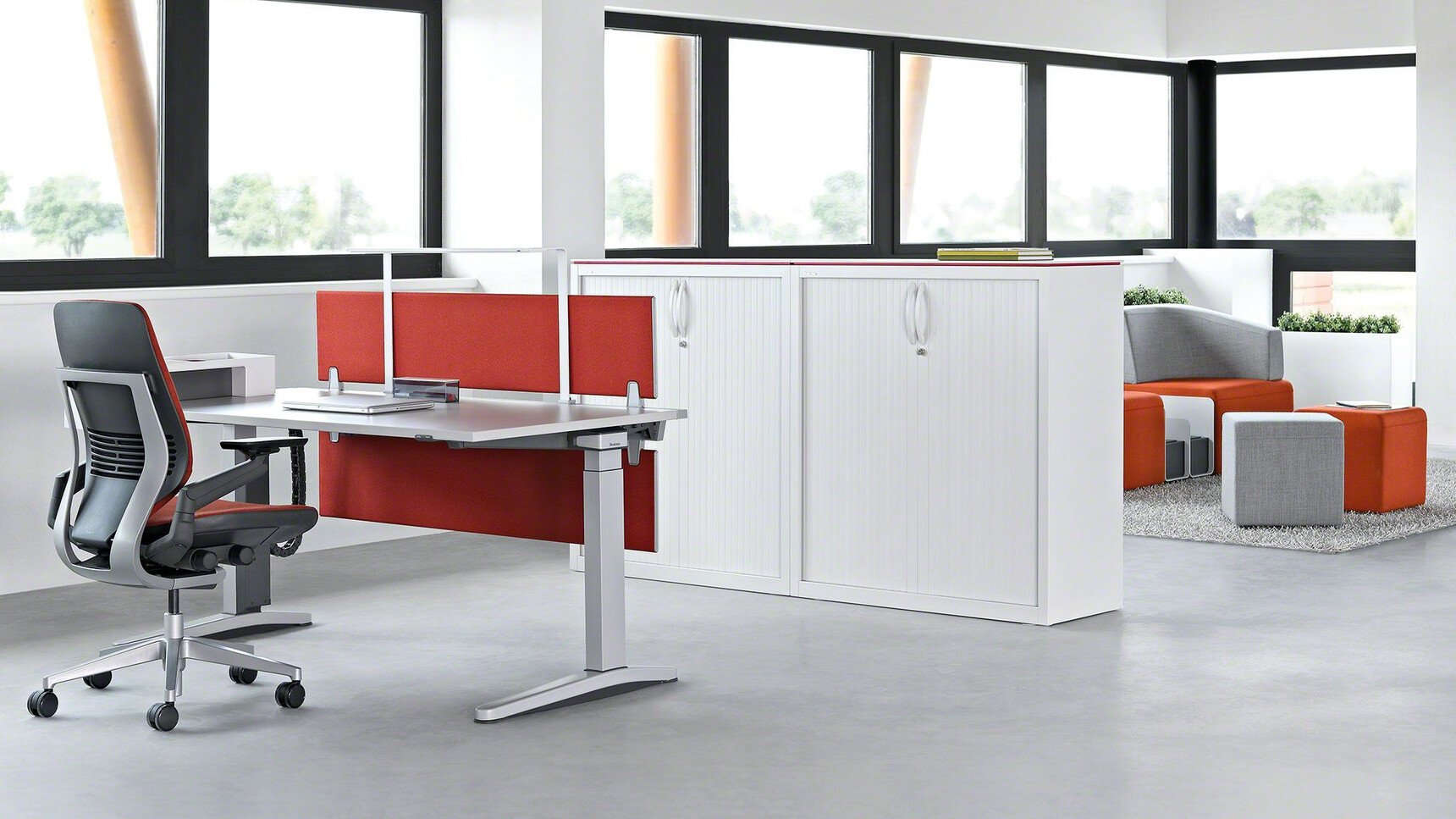 Steelcase Ology Fixed Height Desk With Metallic Table Top And Metallic Legs With Gesture Wrapped Back Office Chair With Dark Orange Upholstery With Black And Grey Frame And Polished Aluminium Base At Desk