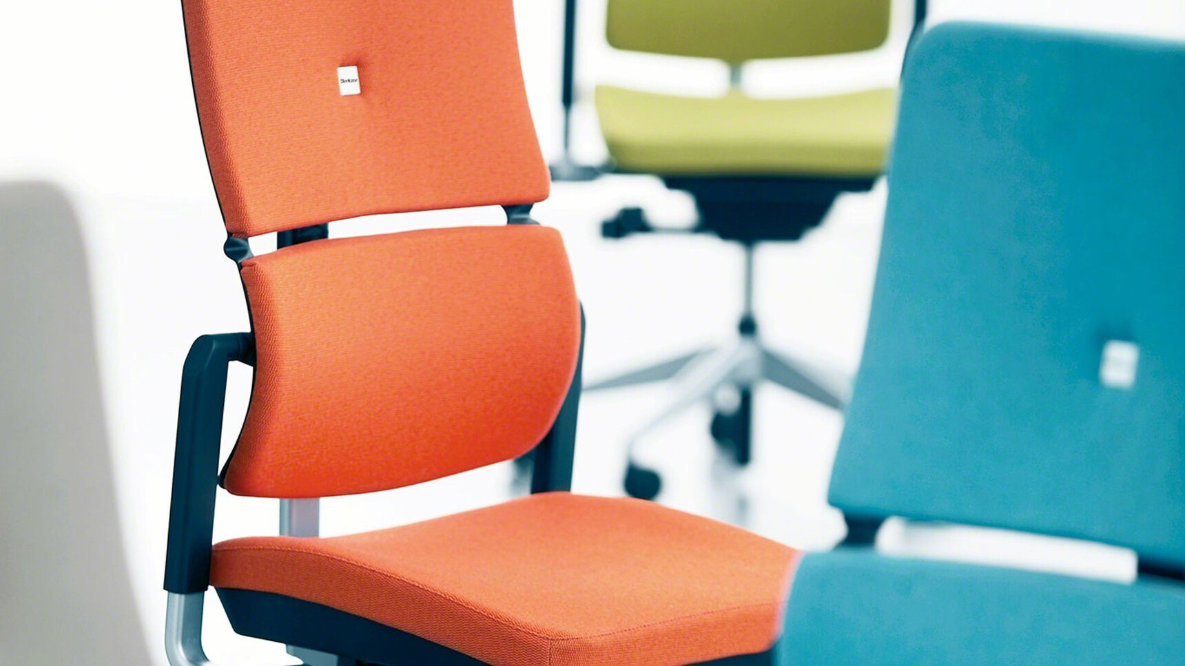 Four Steelcase Please Office Chairs In Green Orange Blue And Grey Upholstery Detail Image