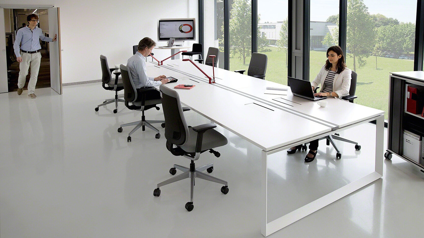 Six Steelcase Reply Upholstered Office Chairs Polished Aluminium Base Grey Upholstery Black Frame At Frameone Bench Desk White Finish White Loop Leg Three People In Room