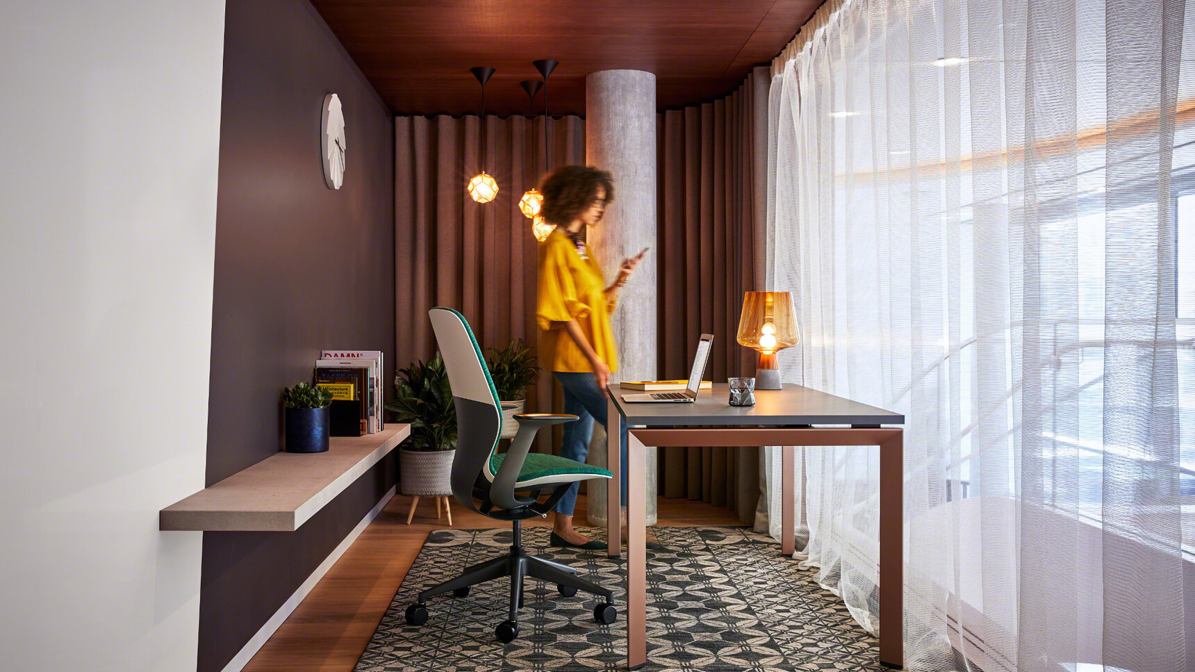 Steelcase SilQ Upholstered Office Chair With Green Upholstery And Black And White Frame And Black Base At Frameone Desk With Black Table Top Finish And Dark Brown Leg Finish With Person In Office