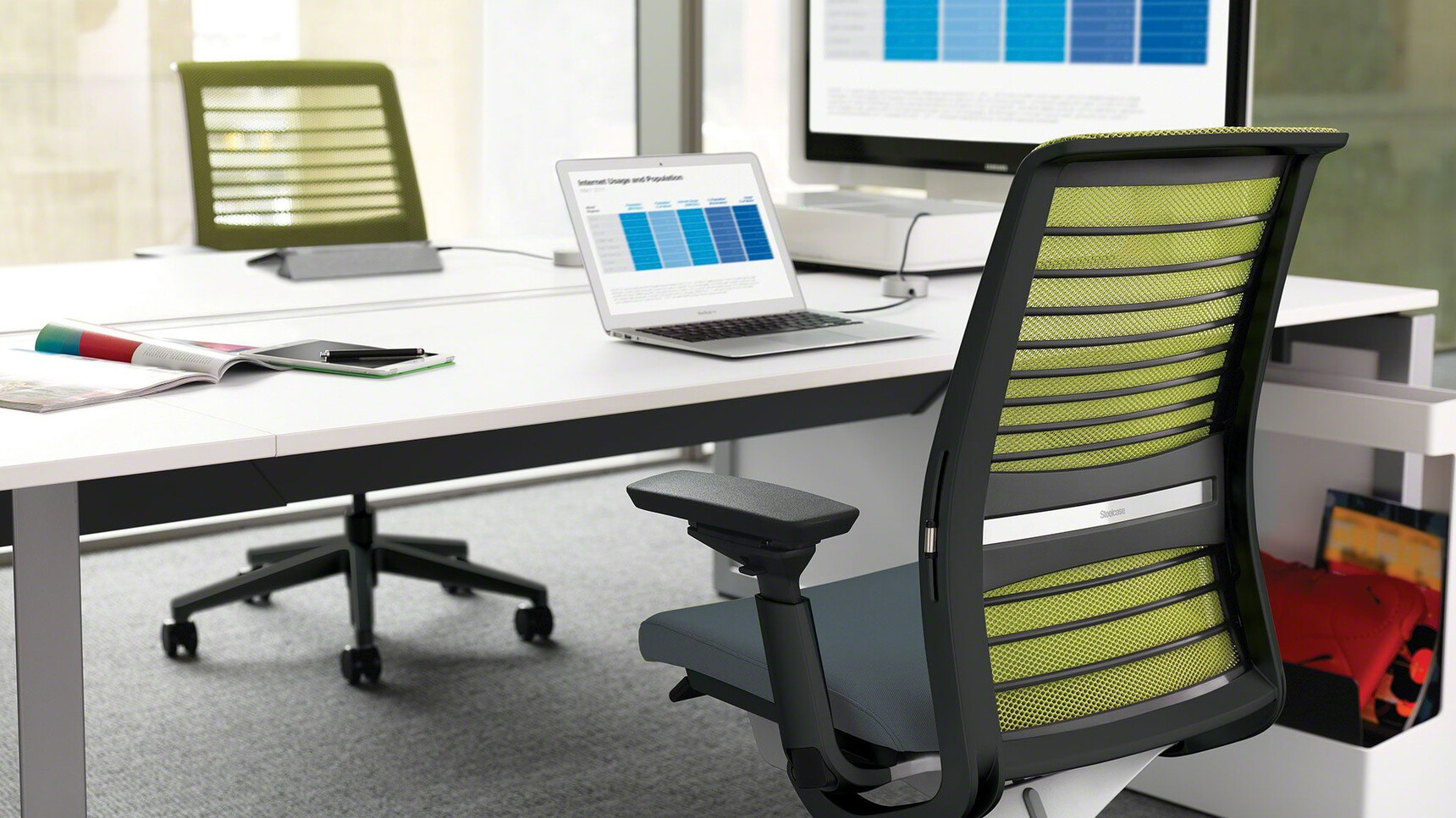 Two Steelcase Think 3D Knit Back Office Chairs With Black Upholstery Frame And Base With Green Upholstery At Steelcase Desk Detail Image