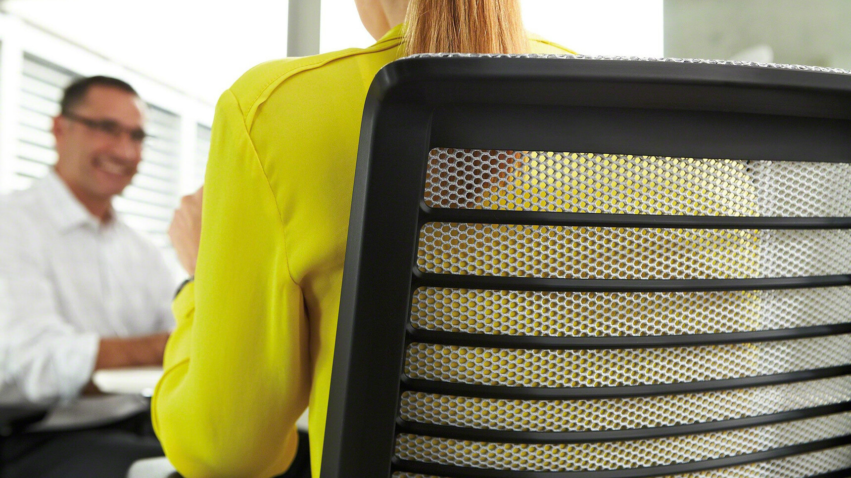 Two Steelcase Think Draughtsman Office Chairs With Black Frame And White Backrest In Use By Two People Detail Image