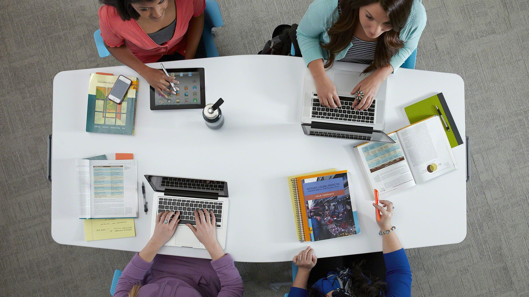 Steelcase Verb Chevron for Two Desks With White Table Top Finish On Node Chairs In Use By Five People In Educational Environment Overhead Image
