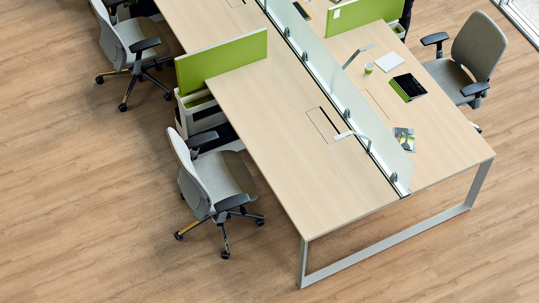 Steelcase Frameone Loop Leg Desk With Light Wood Table Top Finish And Grey Loop Leg Finish With Three Steelcase Office Chairs With Grey Upholstery And Polished Chrome Base And Grey Frame And Black Armrest