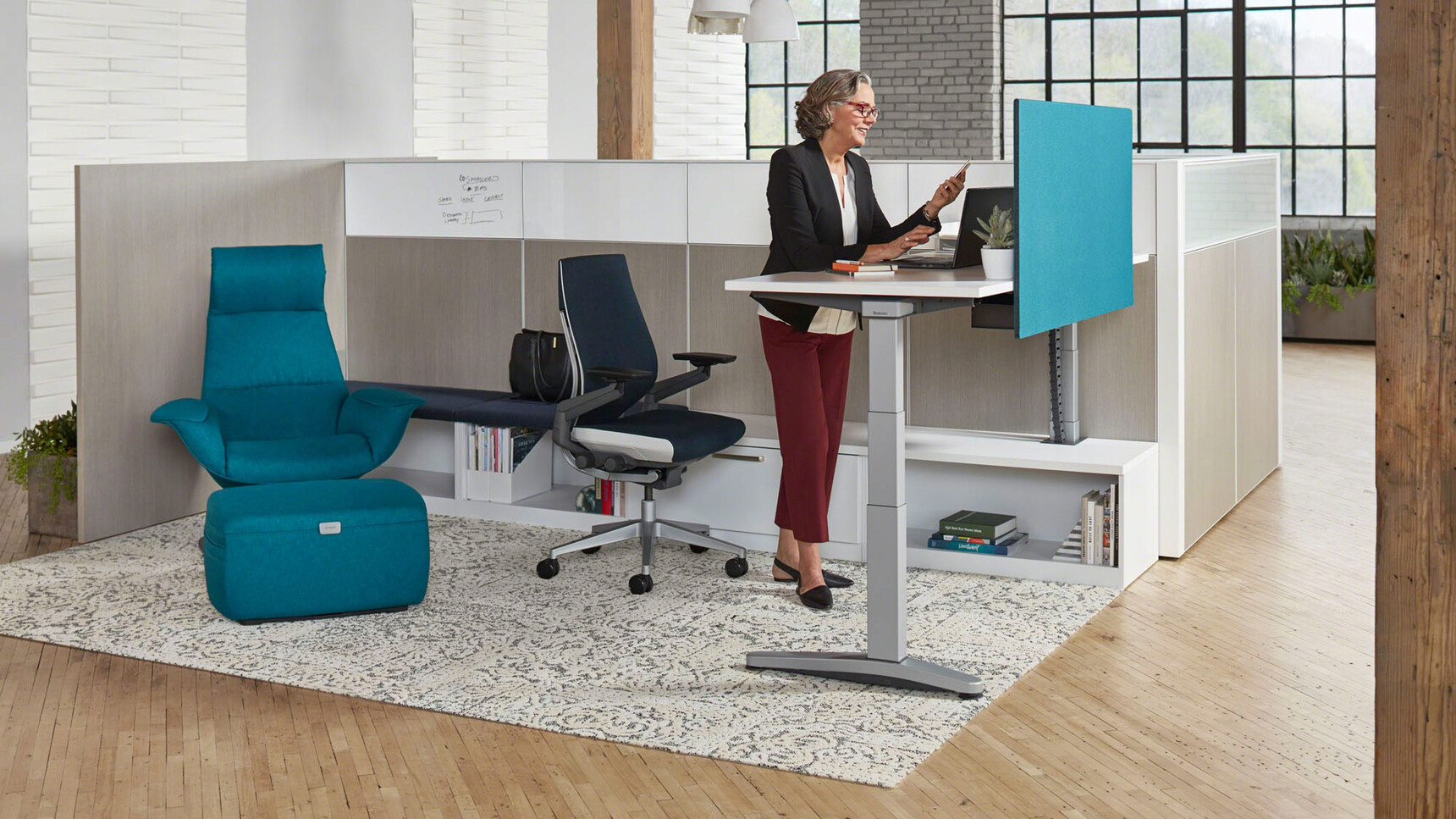 Steelcase Ology Height Adjustable Desks with Simple Touch With White Table Top And Grey Leg Finish With Personal Screen In Blue Upholstery With Gesture Wrapped Back Office Chair With Dark Blue Upholstery At Desk