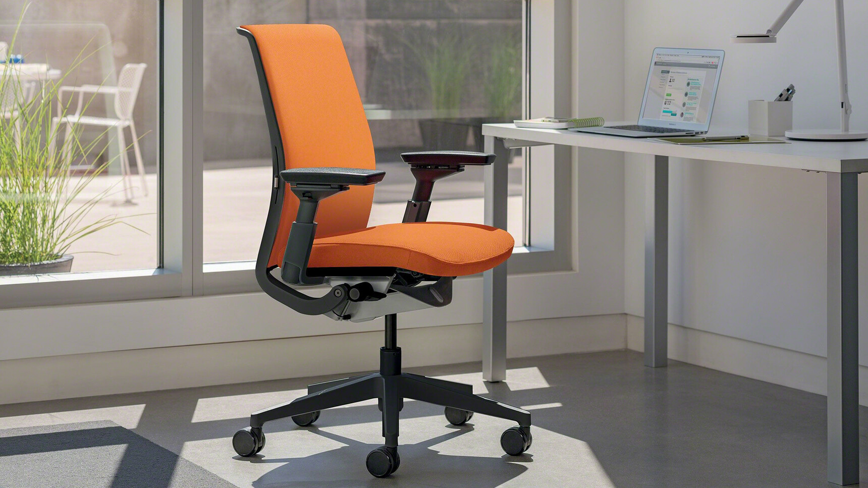 Steelcase Think Fully Upholstered Office Task Chair Insitu At Fixed Height Desk Front View