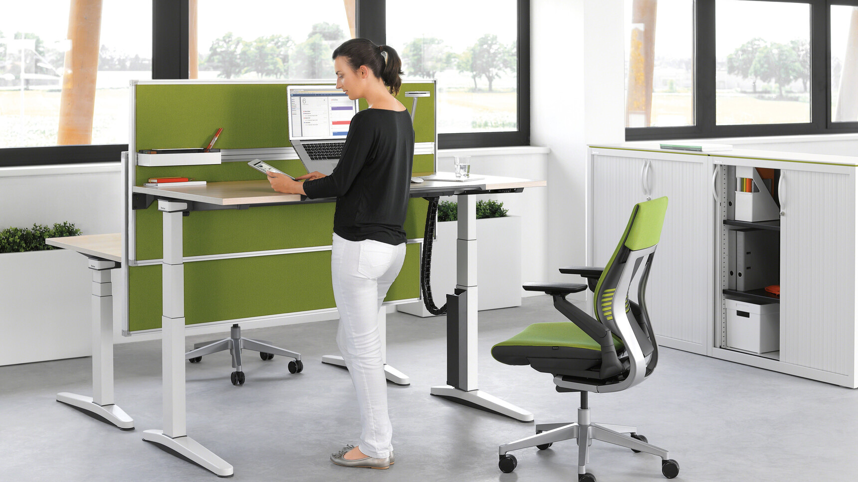 Two Steelcase Migration Height Adjustable Desks Grey Legs Wood Top Two Steelcase Gesture Wrapped Back Green Upholstery At Desk