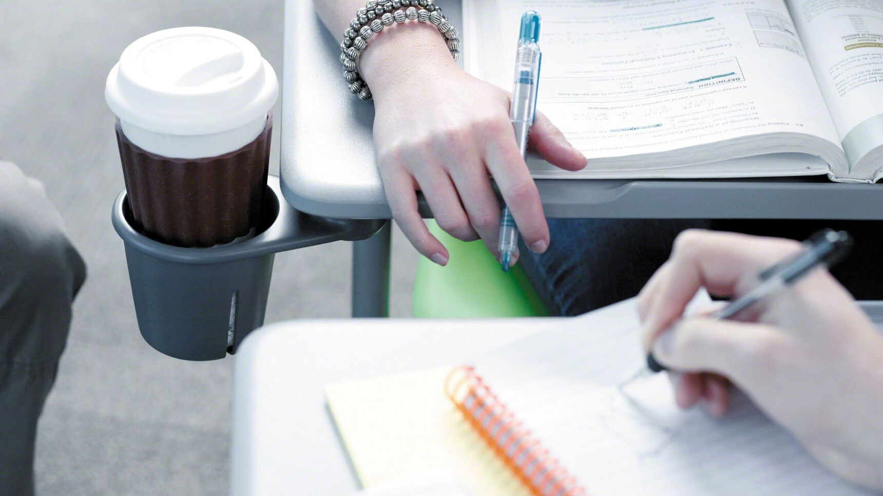 Two Steelcase Node Tripod Base Chairs with Table With Plastic Back And Seat In Green Close Up On Tables In Use