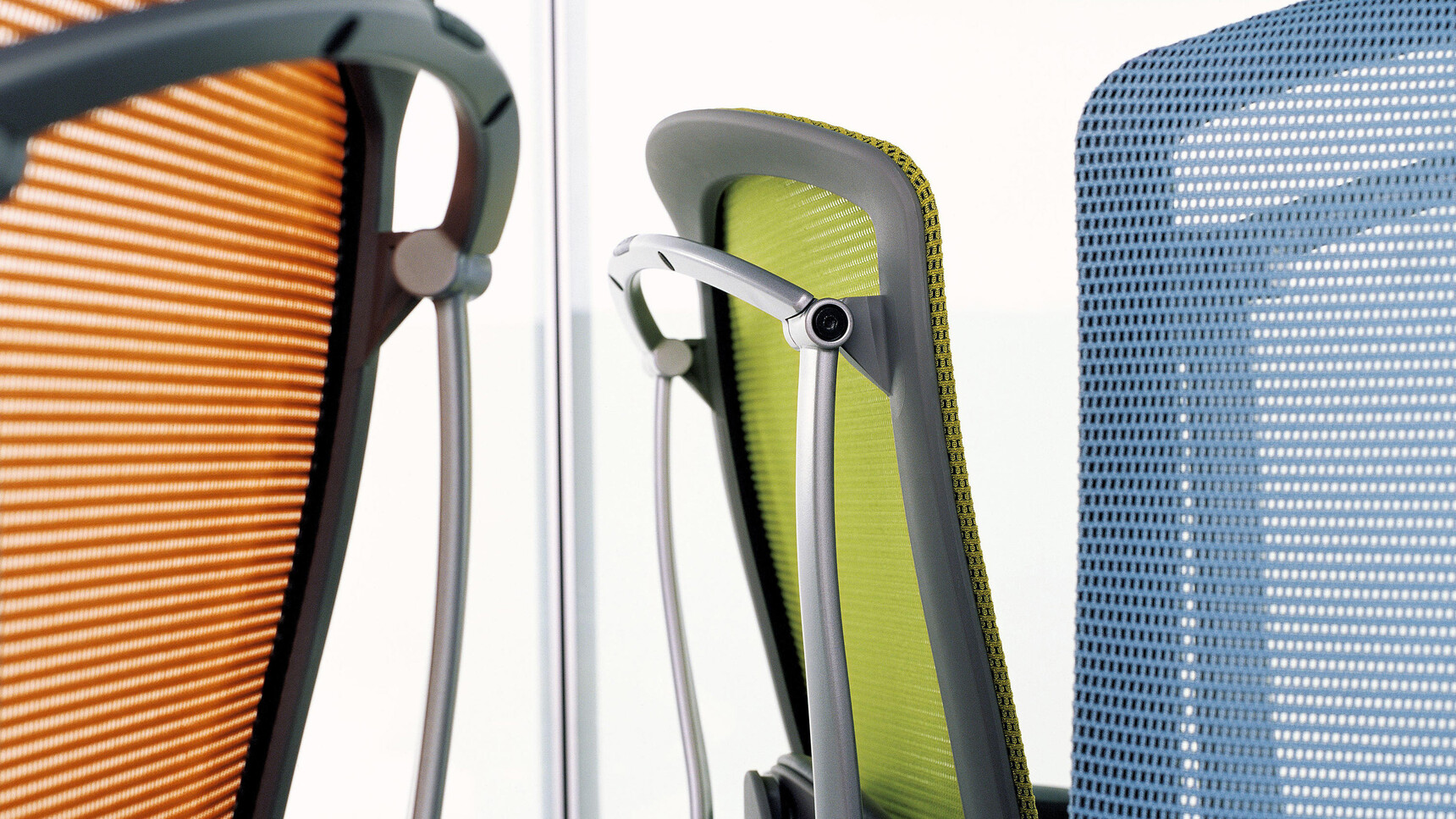 Three Okamura Contessa II Mesh Seat & Back Office Chairs One In Orange One In Green One In Blue With Grey Black Frame Detail Image