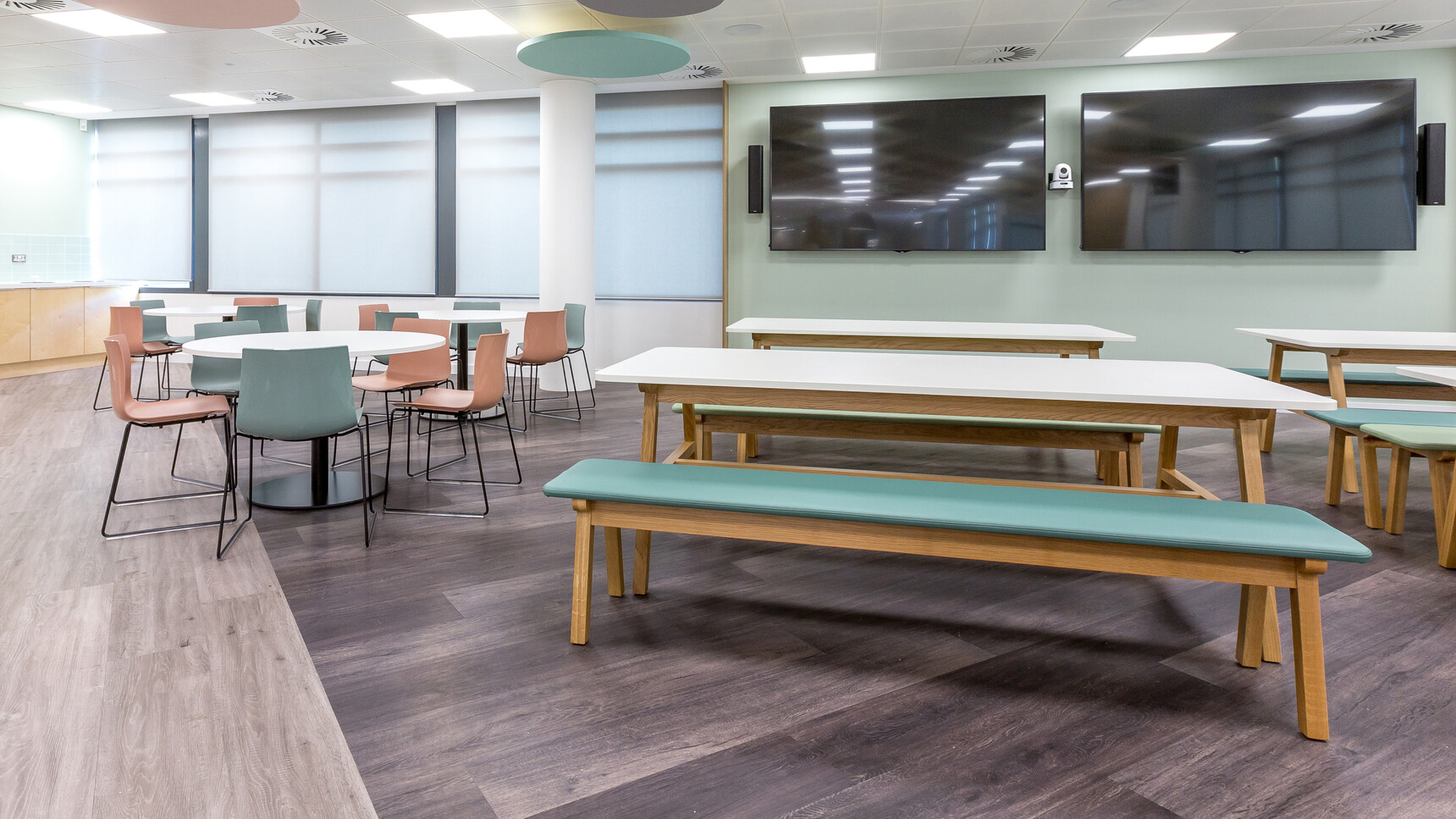 Five Boss Design Agent Benches Three In Blue Upholstery And Two In Light Green Upholstery With Wood Finish At Agent Four Leg Tables With White Table Top Finish And Wood Base Finish