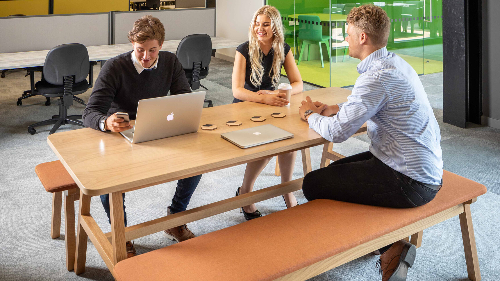 Two Boss Design Agent Benches In Dark Orange Upholstery With Timber Four Leg Wooden Base Finish At Agent Four Leg Tables With Wood Finish In Use By Three People