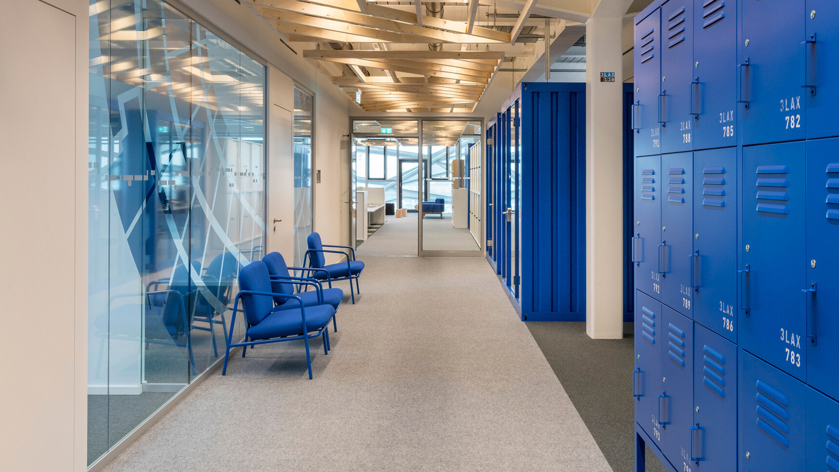 Three Working Lounge Armchairs Blue Frame Finishes With Blue Lockers In Office Setting