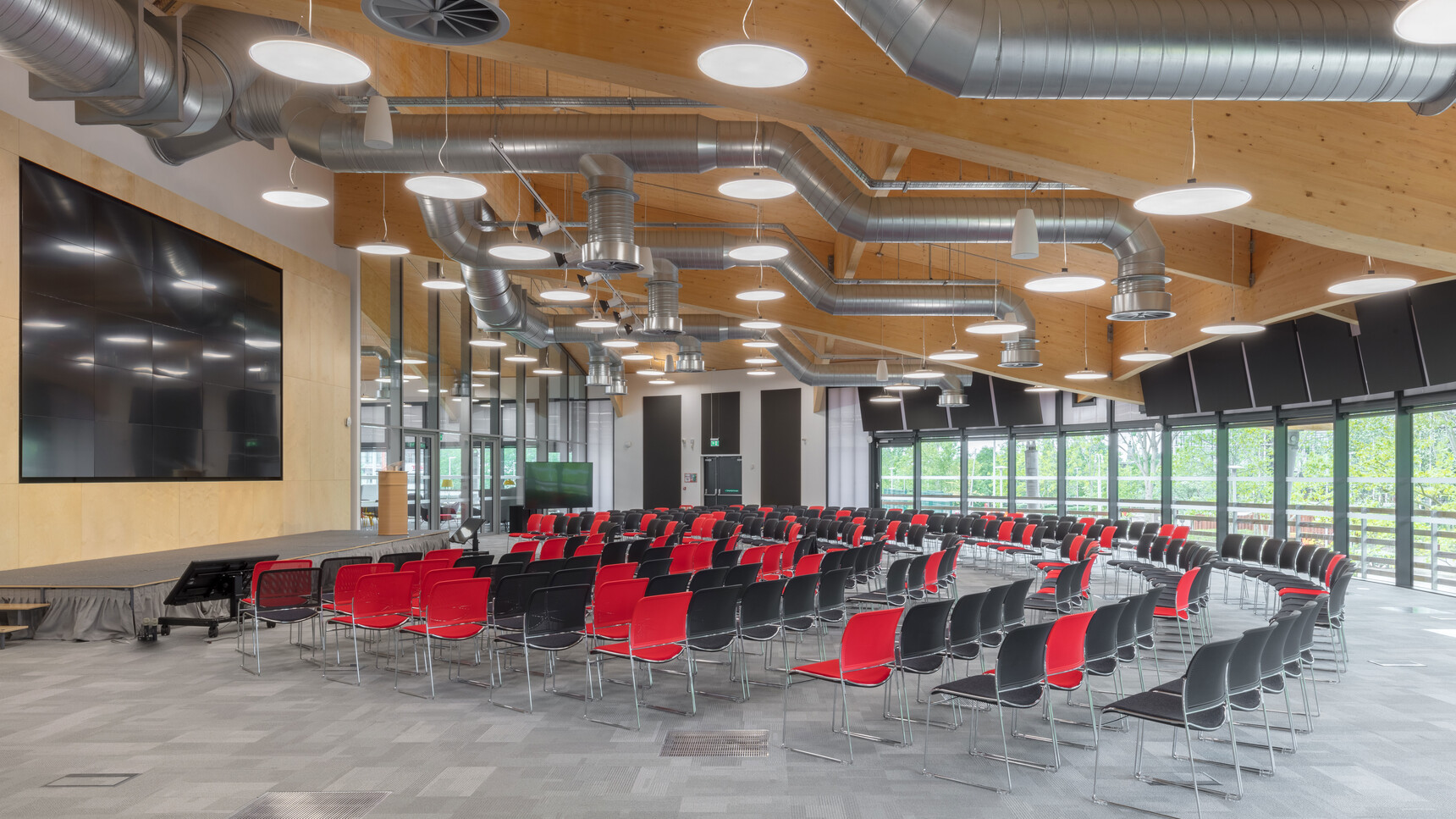 Various Boss Design Starr Armless Meeting Chairs In Red And Black Upholstery And Chrome Base Facing Screen