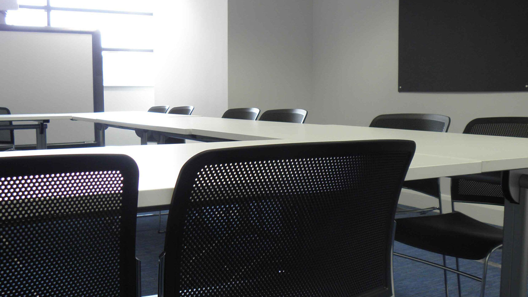 Various Boss Design Starr Armless Meeting Chairs In Black Upholstery And Chrome Base At Table