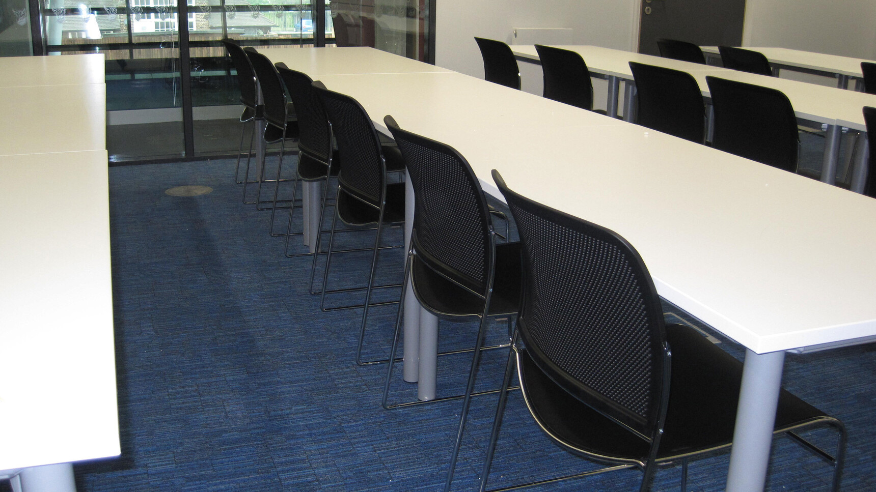 Various Boss Design Starr Armless Meeting Chairs In Black Upholstery And Chrome Base At White Desks