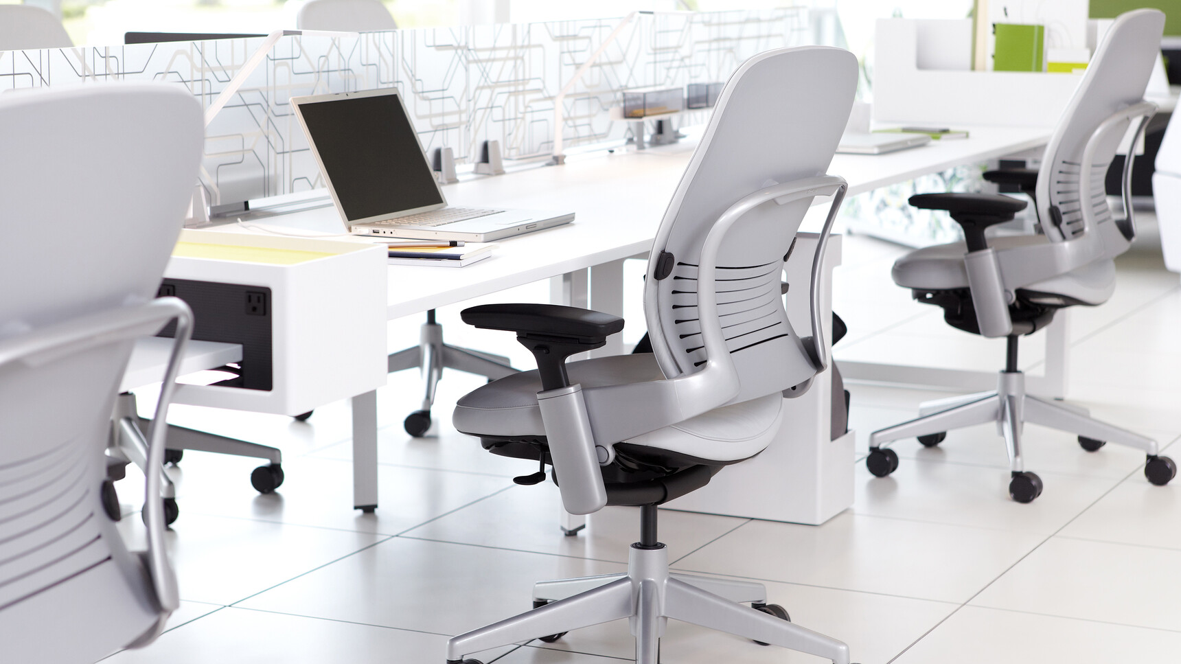 Three Steelcase Leap Leather Office Chairs With Grey Leather And Black Metallic Base At Desk In Office Environment