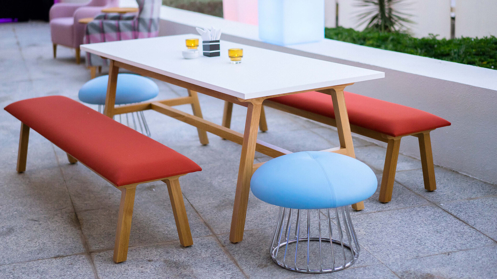 Two Boss Design Agent Benches With Red Upholstery And Timber Four Leg Wooden Base Finish At Agent Four Leg Table With White Table Top Finish And Wood Base Finish With Two Magic Island Stools At Desk