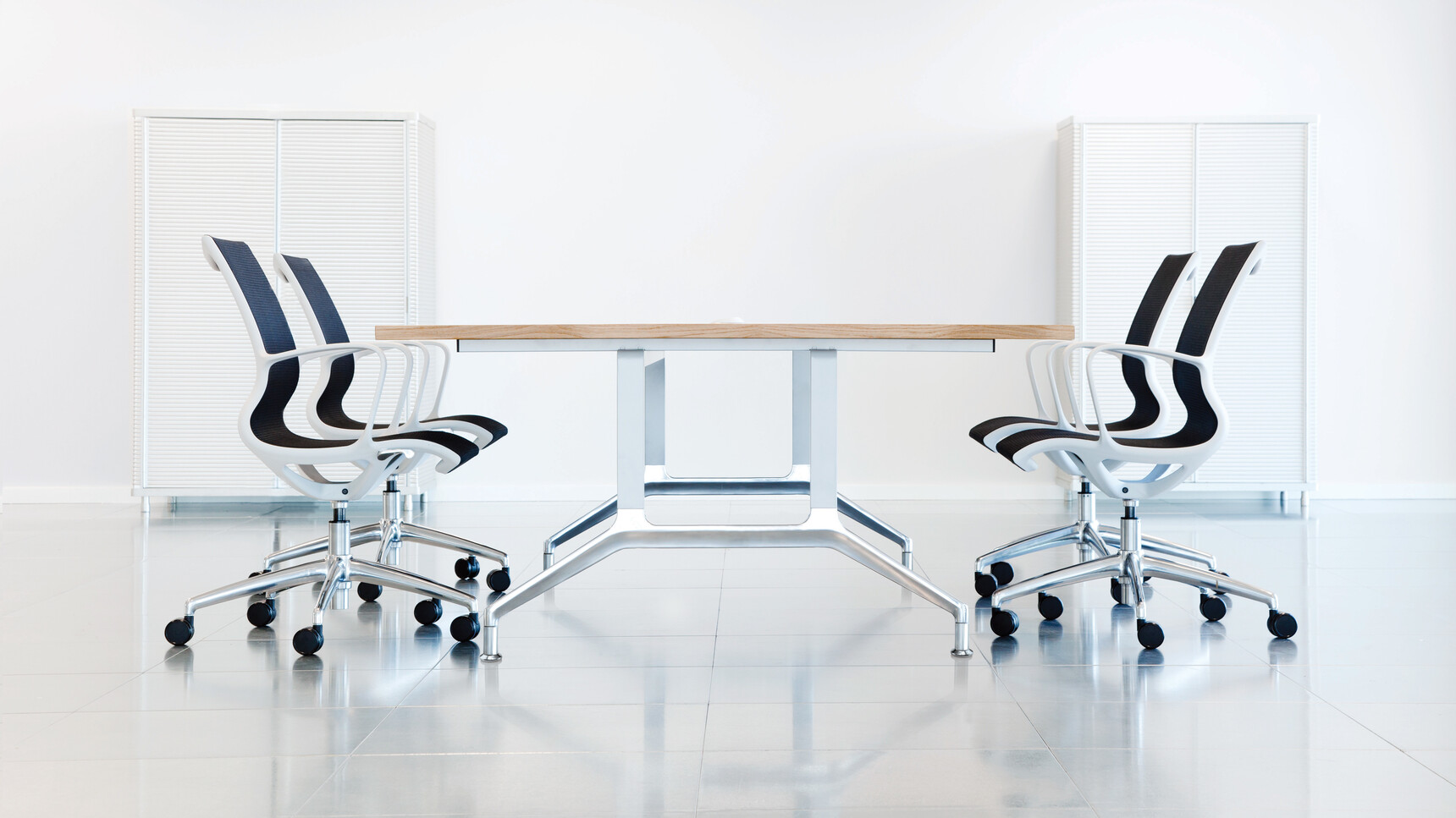 Four Boss Design Kara Office Chairs with Arms With Black Upholstery With White Frame And White Armrests And Polished Aluminium Base On Castors At Desk In Meeting Room