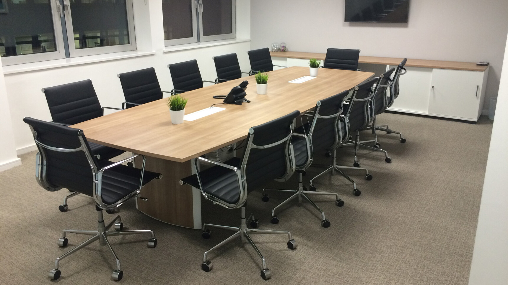 Elite Aerofoil Boardroom Table Two Section Top With Wood Finish Table Top And Legs With Grey Leg Edges And Twelve Elite Black Chairs In Boardroom