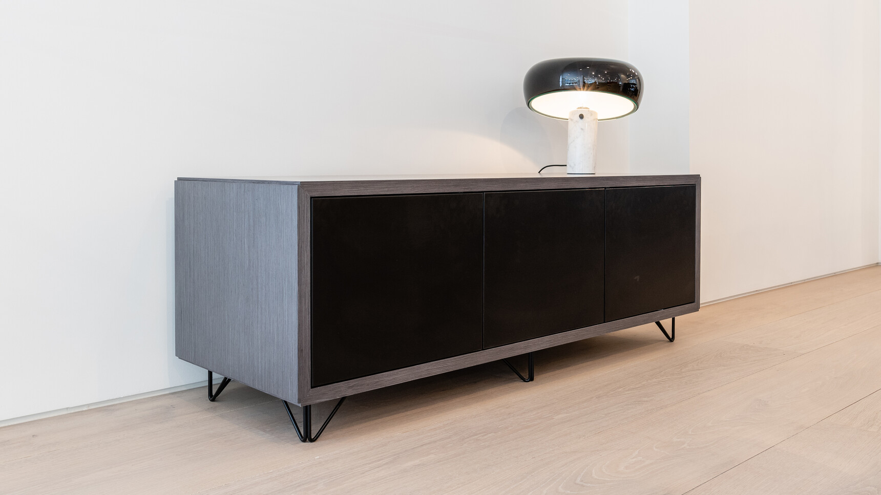Boss Design 548H Credenza with Wire Feet & Doors With Three Touch Latch Doors In Black Finish And Wood Frame Finish On Wire Feet With Black Finish At Wall With Lamp On Table