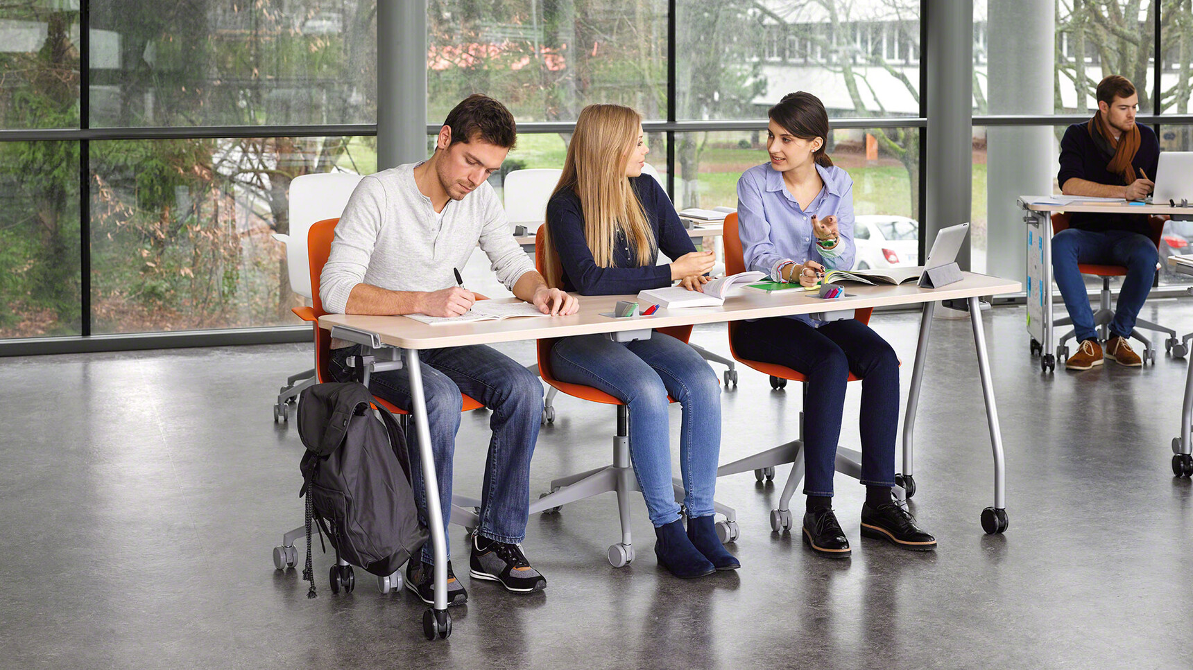 Four Steelcase Verb Rectangular Desks With Wood Table Top Finish And Grey Leg Finish On Castors One With Optional White Board Easels Seven Node 5 Star Base Chairs In Educational Environment